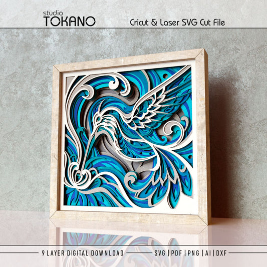 Framed hummingbird layered wall art shown as a flowing floral papercut design with soft botanical shapes and 3D depth.