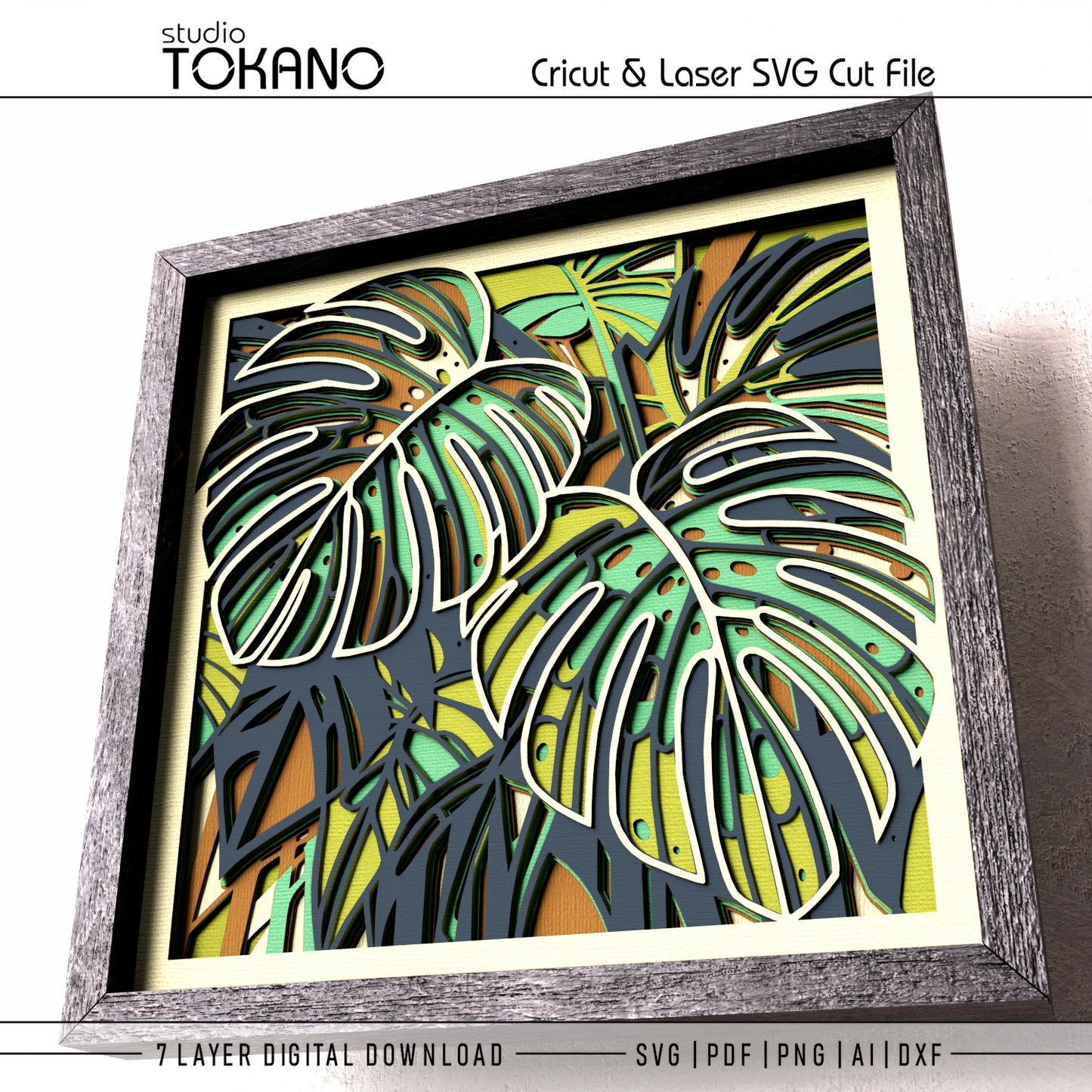 A framed tropical leaf art print with layered monstera and palm leaves in green, yellow, orange, and dark gray tones, shown on a white background with text reading 'studio TOKANO' and 'Cricut & Laser SVG Cut File' plus '7 LAYER DIGITAL DOWNLOAD' and file formats at the bottom.